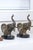 A pair of silvered finely textured bronze metalwork bookends cast as elephant heads mounted on an oval black lacquered...