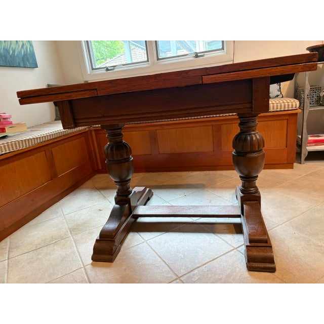A stately Jacobean Revival refectory table in solid English oak, dating to the early-to-mid 20th century. This piece is...