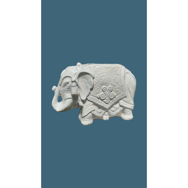 A charming vintage sculptural elephant planter or cachepot in glossy white glazed ceramic. The elephant is modeled in...