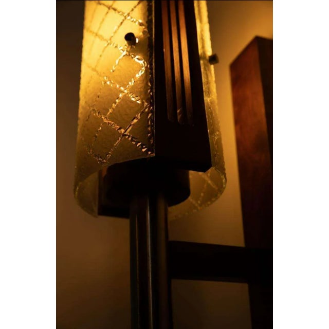 Chic designed wall lamp from the sixties with Scandinavian influences. The lamp has a rectangular, slender solid teak wall...