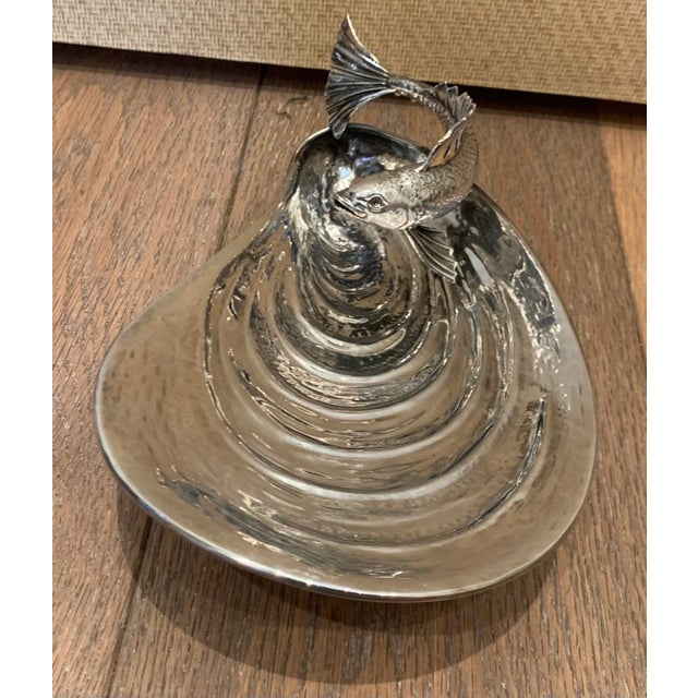 Vintage metal serving dish in the form of a shell with a fish handle.