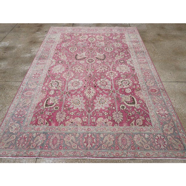 This early 20th-century Persian Tabriz accent carpet presents a richly detailed allover floral composition across a vivid...