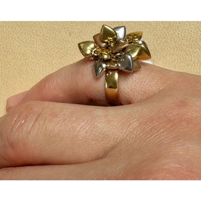 This 18 karat gold ring features close to 20 different heart charms, Yellow rose and white gold Heart Charms are bunched...