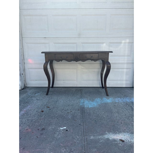 We have a beautiful vintage French Provincial console table for sale, designed in a classic Louis XV style with cabriole...