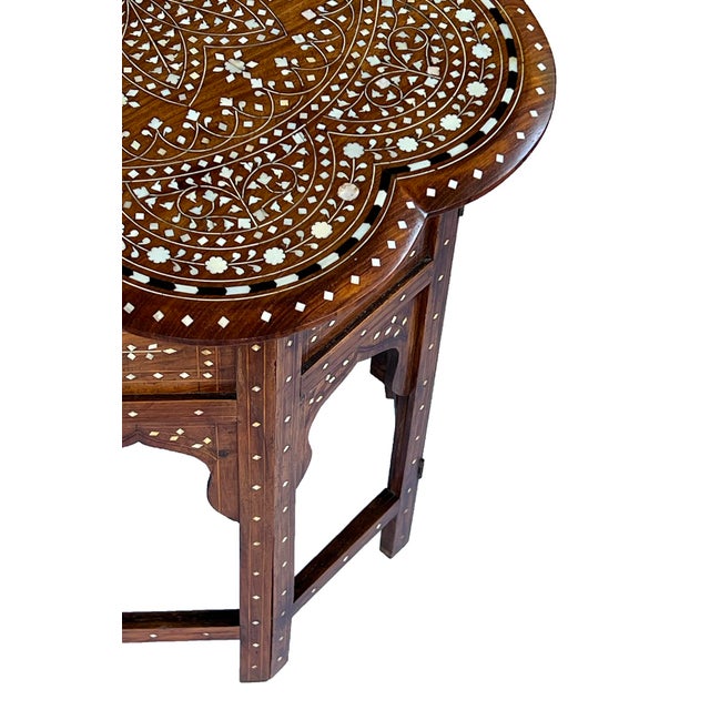originally used as traveling tea tables for the British in India; the scalloped top of rare form centering a large...