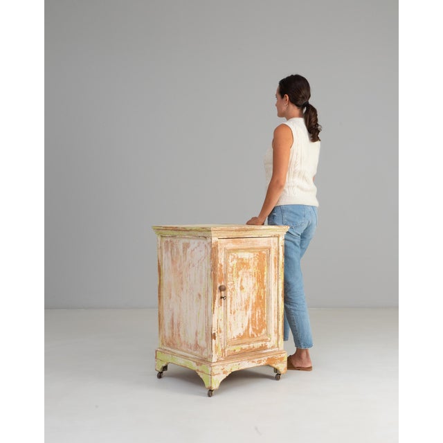 19th Century French Wood Patinated Cabinet With Wheels. This character-rich cabinet showcases the beautifully aged patina...