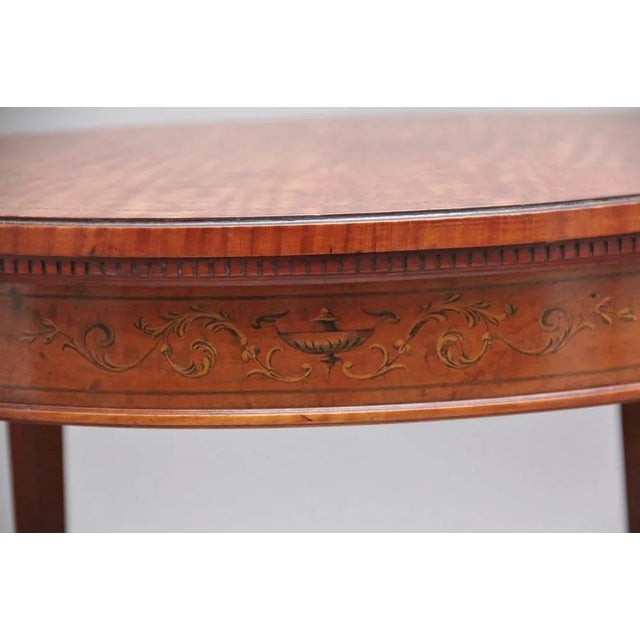 19th Century satinwood and inlaid occasional table in the Sheraton style, the moulded circular top having an inlaid border...