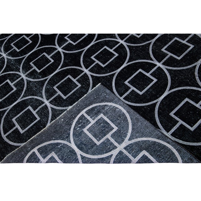 Beautiful Turkish handmade wool rug with a black distress look field. This Modern rug has white accents featuring a...