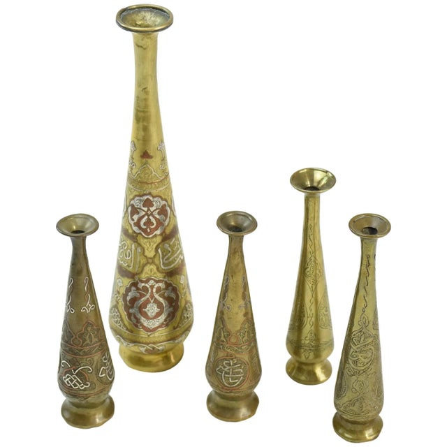 Group of five slender engraved brass flower vases dating to around 1900, probably Syrian or linked to the Damascus...