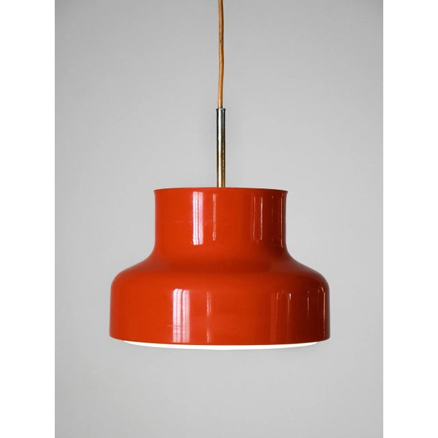 The vintage Bumling lamp, designed for Ateljé Lyktan, is an iconic example of 1960s Scandinavian design. Made of orange...