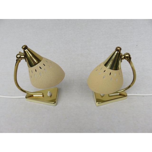 This set of two lamps feature a perforated shade, creating a special light effect. The bases are brass combined with light...