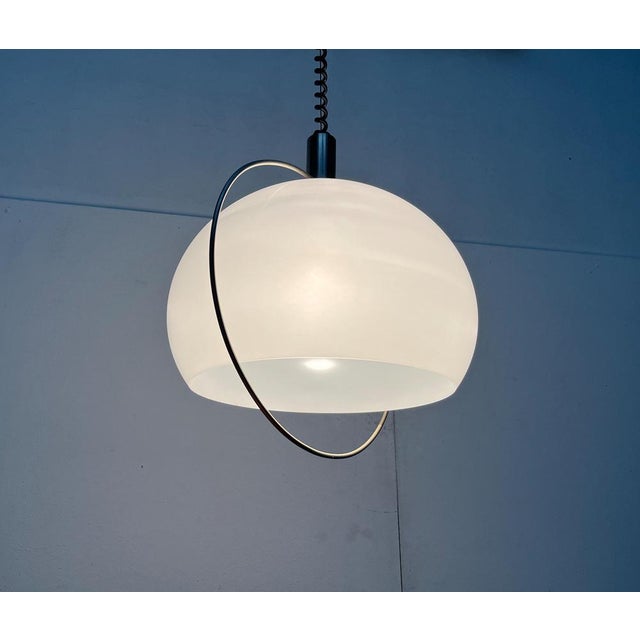 Space Age train pendulum from Temde. The white balloon shade is framed by a fine metal bracket. This primarily serves as a...