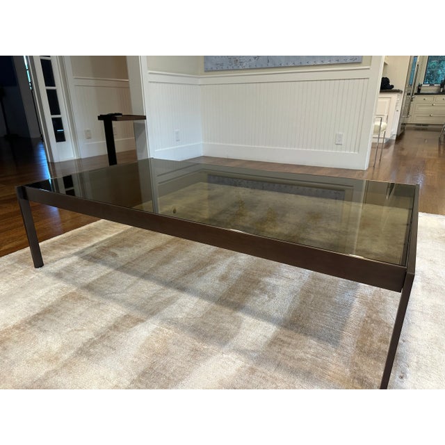 Sophisticated in scale and form, this coffee table features a bronze glass top nestled securely within its sleek metal...