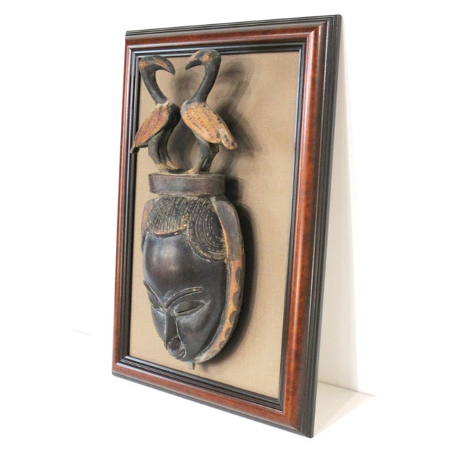 A unique handcrafted wooden African mask with two birds / Anoman on the upper head piece blending human and animal forms...