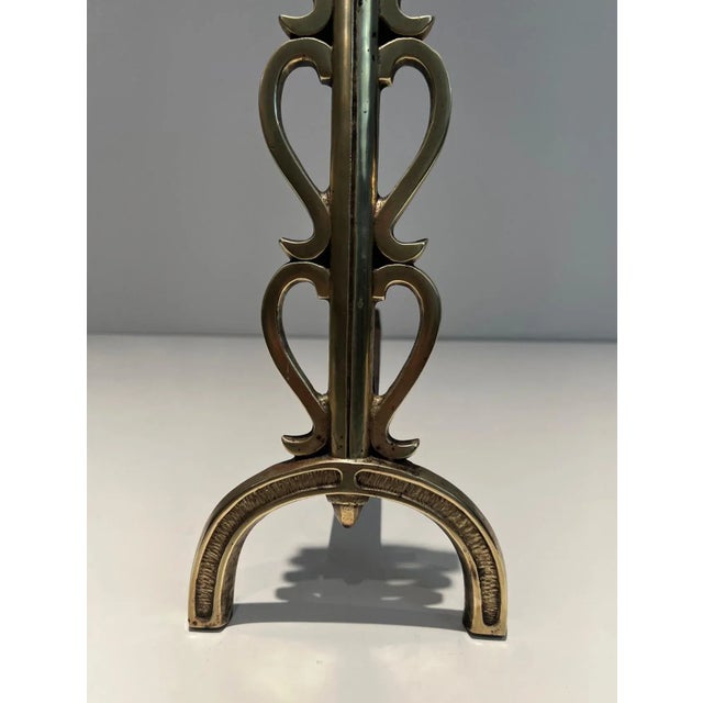 This pair of andirons is made of brass and wrought iron. This is a French work in the style of famous French designer...