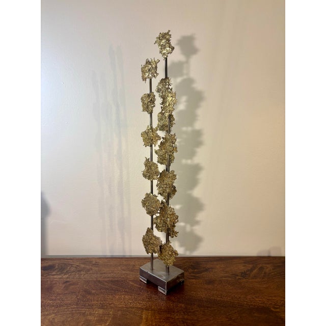 A striking Brutalist vertical sculpture signed D. Larson, 2012. Composed of three steel rods rising from a solid steel...