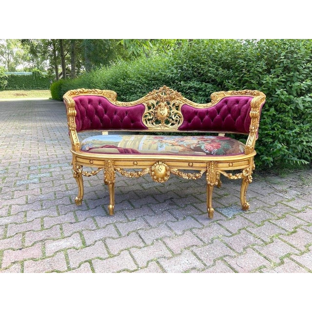 A beautiful 1950s French Louis XVI–style settee, combining a finely carved solid beechwood frame with sumptuous burgundy...