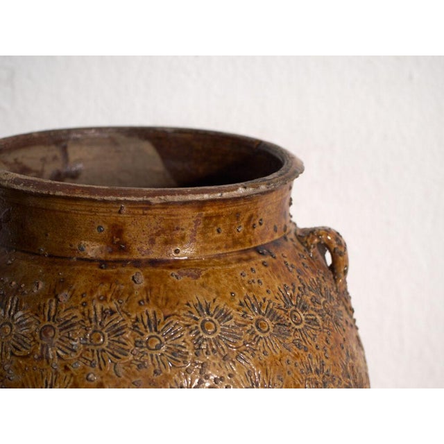 This antique Chinese glazed stoneware vase is an ovoid jar with a ochre-amber glaze, lug handles and stamped decoration of...