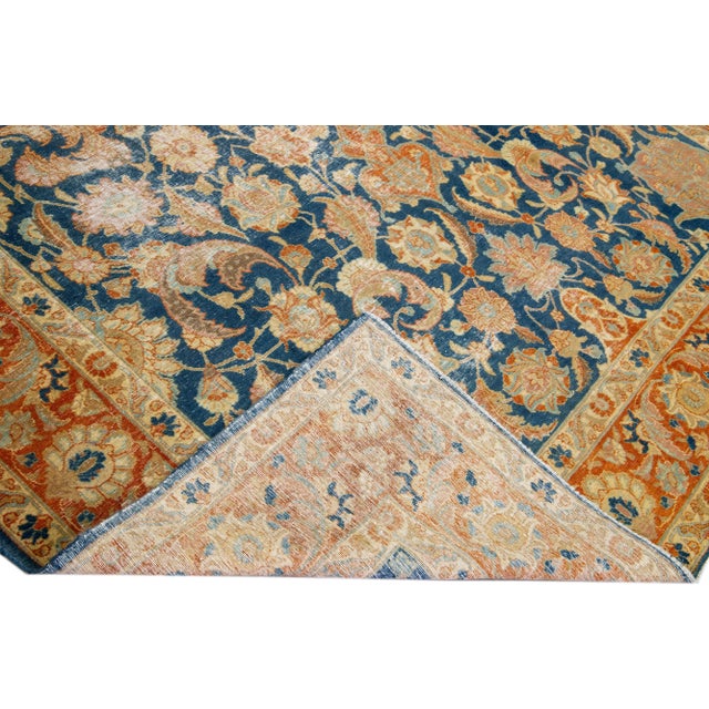 Beautiful vintage Persian distressed hand-knotted wool rug with a navy blue color field. This piece has a rust frame and...