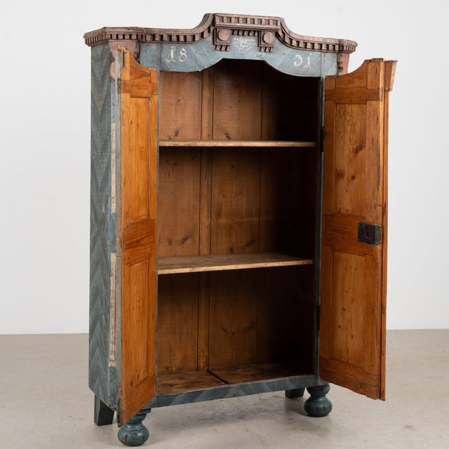 Hungarian two-door armoire dated 1831, crafted in pine with a remarkable original hand-painted folk art finish. Blue and...