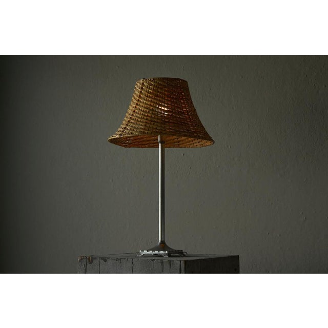 A beautiful swedish grace style pewter table lamp with rattan shade. Sweden, 1930s-1940s. Features a wonderful stepped...