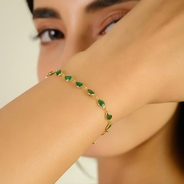 This elegant station bracelet features 20 natural pear-cut emeralds with a total weight of approximately 3.7 carats, set...