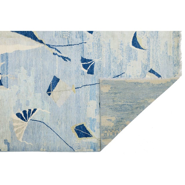 Enhance your space with this modern wool rug featuring a playful “kites in flight” design. Set against a textured, multi-...