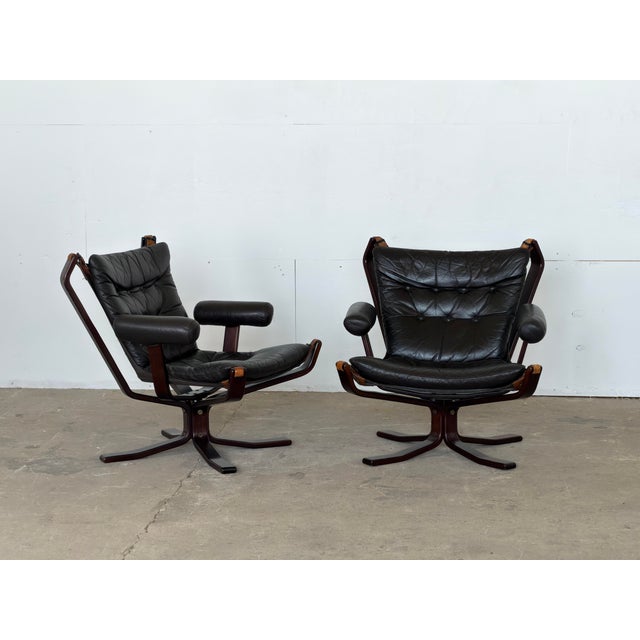 A pair of black leather Falcon lounge chairs by Sigurd Ressell, produced by Vatne Møbler, Norway, 1970s. The defining...
