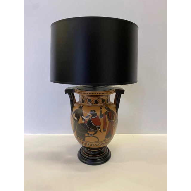 A gorgeous classical Greek style vase having hand painted warm gold background with black and red oxide ancient figures...