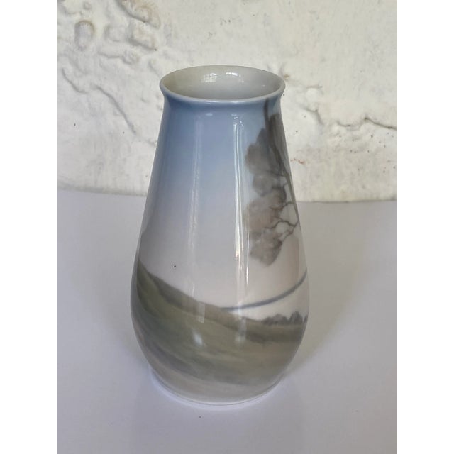 Vintage cabinet vase features a landscape with trees and is an example of Art Nouveau design. Made by Bing & Grøndahl in...