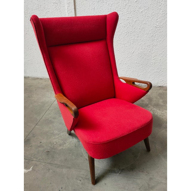 Elegant armchair designed by Chresten Fidahl in Denmark in the 1970s, with red upholstery and wooden armrests. – Vibrant...