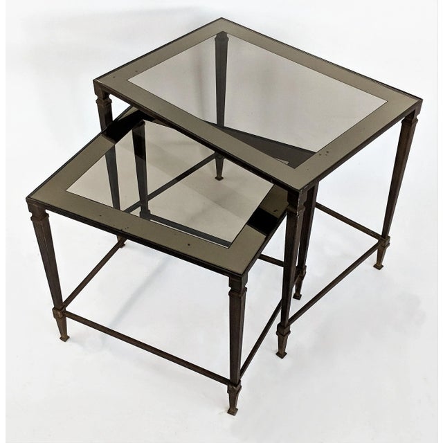 Pair of Nesting Tables by Maison Jansen. Circa 1960. Neoclassical design with bronze bases and glass tops with silvered...