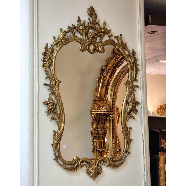 This elegant French Baroque style wall mirror features a richly detailed gold leaf frame with beautifully hand-carved...