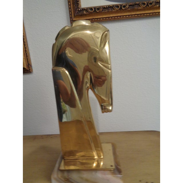 Vintage Hollywood Regency style brass horse head sculpture. It features a sleek, stylized modernist profile. Highly...