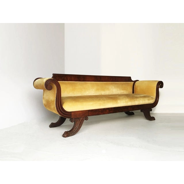 Classic upholstered in yellow gold velvet carved mahogany Grecian sofa. With highly figured mahogany veneers on carved...
