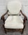 This is a stunning vintage Spanish Revival walnut armchair featuring hand-carved acanthus arm terminals, a carved shell...