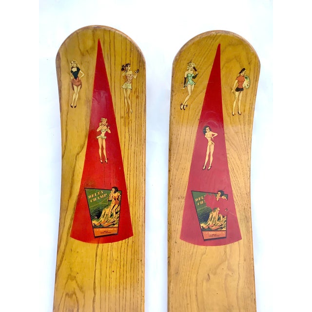 Circa 1940s wood Delta Champ waterskis with original bathing beauty graphics, manufactured by C & T Manufacturing Co.,...