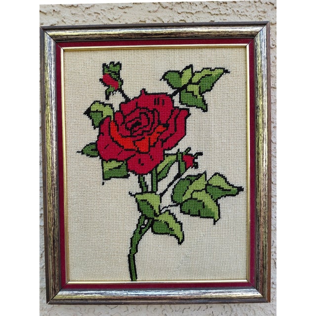 Mid-century red rose framed needlepoint features a long stemmed rose with two rosebuds and leaves on a neutral background....