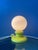 A striking vintage West Germany table lamp featuring a vibrant yellow ceramic base paired with an opaline glass globe...