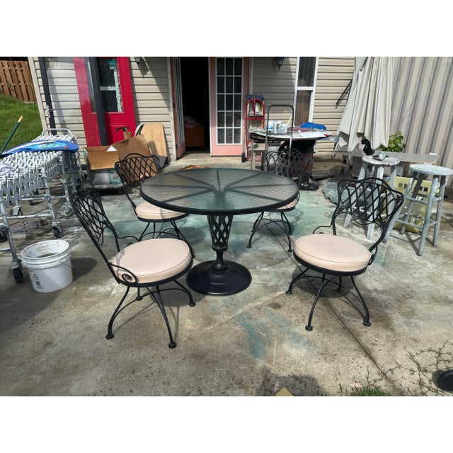Vintage Woodward wrought iron patio set. Glass top table with 4 chairs. Suitable for covered patio with heavy duty vinyl...
