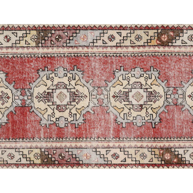 This vintage Turkish Oushak runner, measuring 3'3" x 9'7", is handwoven with wool on a wool foundation in the Oushak...