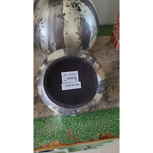 Set of two decorative John Richard orbs. Features an abstract, organic swirl pattern with black, gray, and white tones...