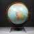 ABOUT A mid-century modern 12-inch Replogle world globe featuring a brass-plated meridian ring and bracket and industrial...