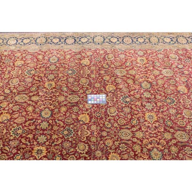 In a popular Persian format, this central Iranian city carpet shows a small palmette, cloud band and spiral vinery allover...