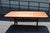 Early 20th-century American pine sawbuck dining table featuring a broad plank top, rounded corners and substantial X-form...