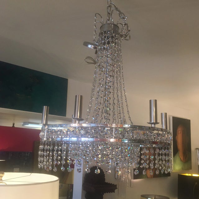 Sparkling crystal chandelier with draping crystals from the crown down to the double chrome banding. It has a smaller...