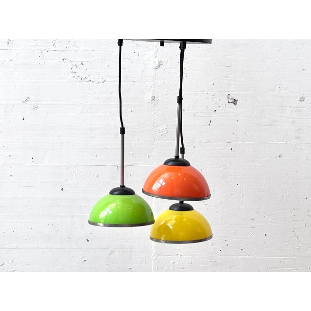 A striking three-light pendant lamp from the 1970s with a characteristic space-age aesthetic. The three hemispherical...