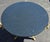 An elegant French Neoclassical-style gueridon table featuring a striking circular black granite top raised on a sculptural...