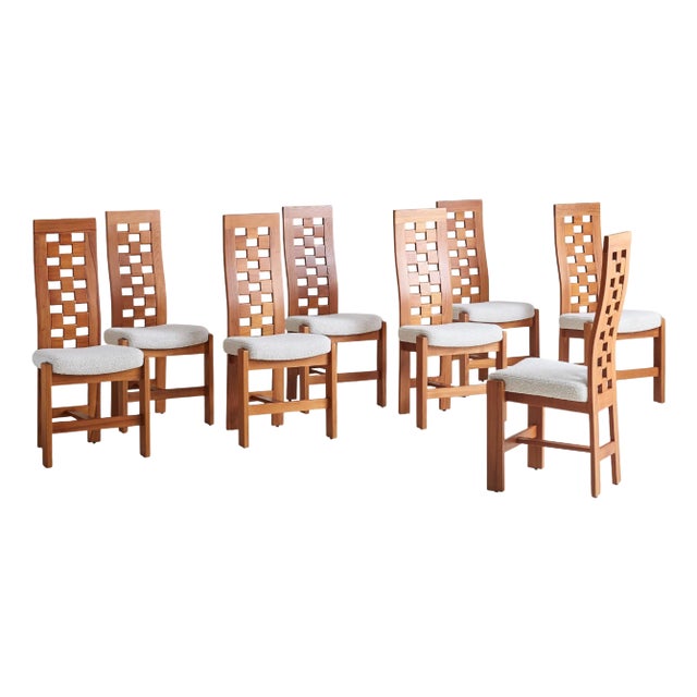 A French dining chair from the 1970s, attributed to Maison Regain. The solid elm frame rests on angular, block legs with a...