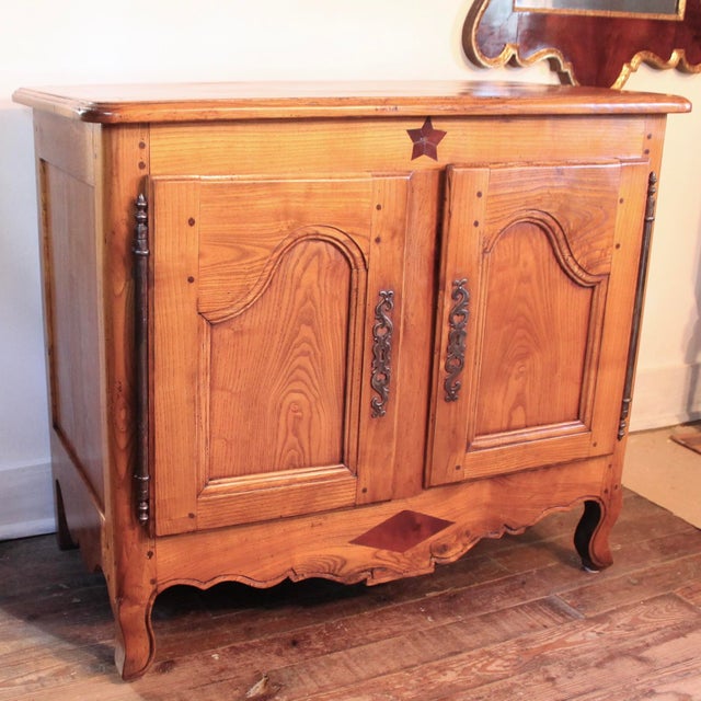 This unusually small cabinet is constructed of warm honey colored elmwood, with its graceful and distinctive attenuated...